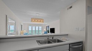 Eine moderne Küche mit großem Fenster, integriertem Spülbecken und Geschirrspüler.