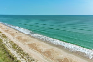 Une plage offrant une vue dégagée sur l’océan et bordée d’un rivage sablonneux.