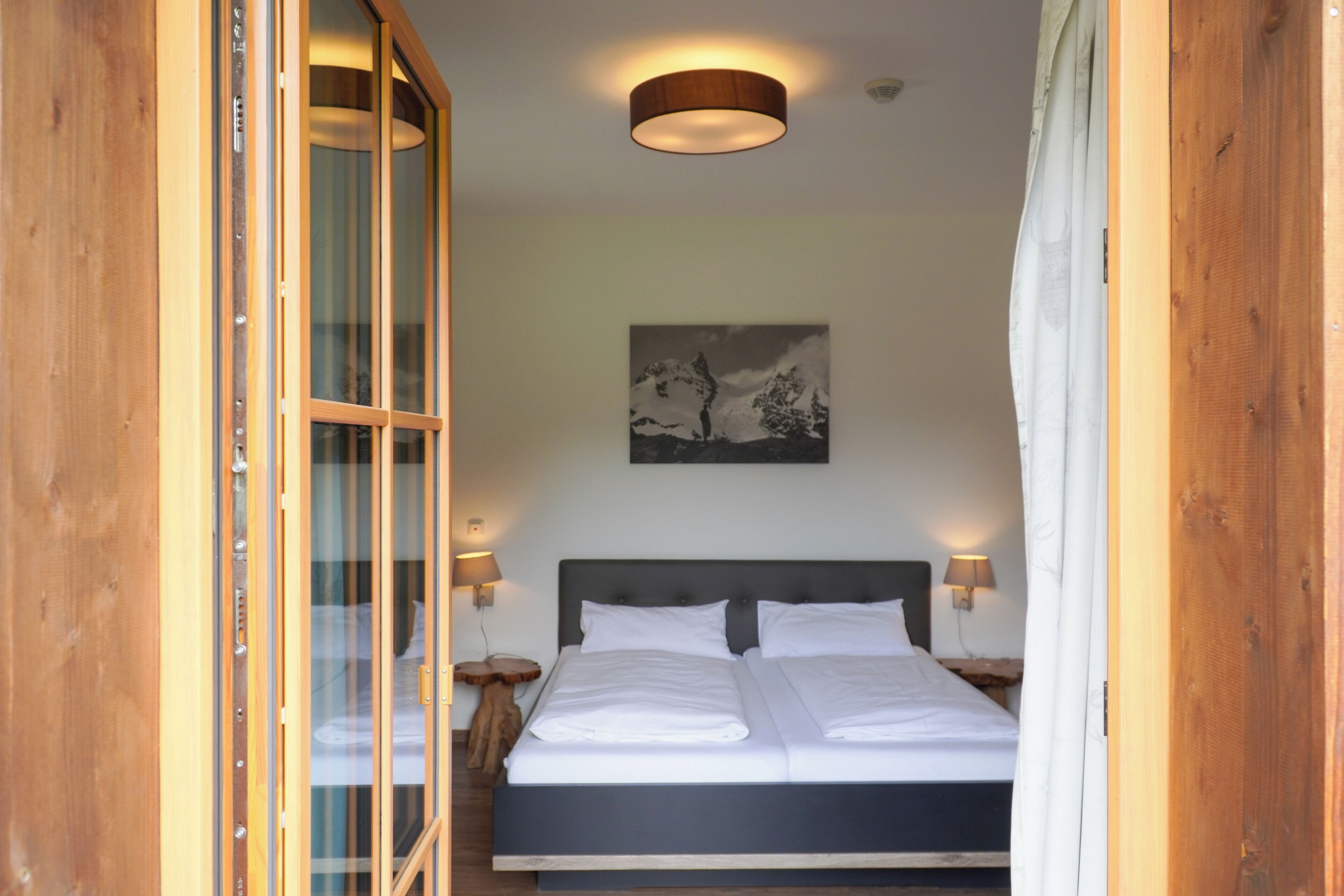 Une chambre à coucher avec un lit, des murs en bois, un luminaire au plafond et un tableau accroché au mur.