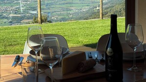 A dining table set with plates, glasses, cutlery, and a bottle of wine, overlooking a mountainous landscape. - Chalet Altea View: panoramic Lake Como, 8 places, garden and barbecue. (Mello)