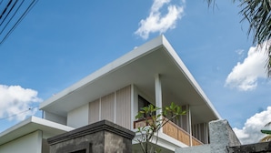 A modern two-story house with a balcony, a gated entrance, and lush greenery. - Kemari Ubud (Ubud)