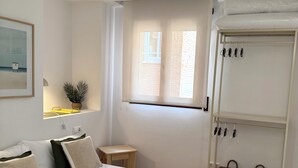 Ein ordentlich eingerichtetes Schlafzimmer mit Bett, Nachttischen, einem Fenster und einem Kleiderschrank.