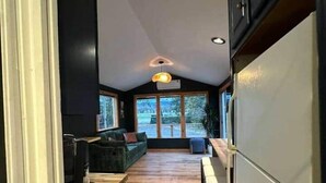 Une cuisine moderne avec un plancher en bois, des armoires noires et un grand réfrigérateur.