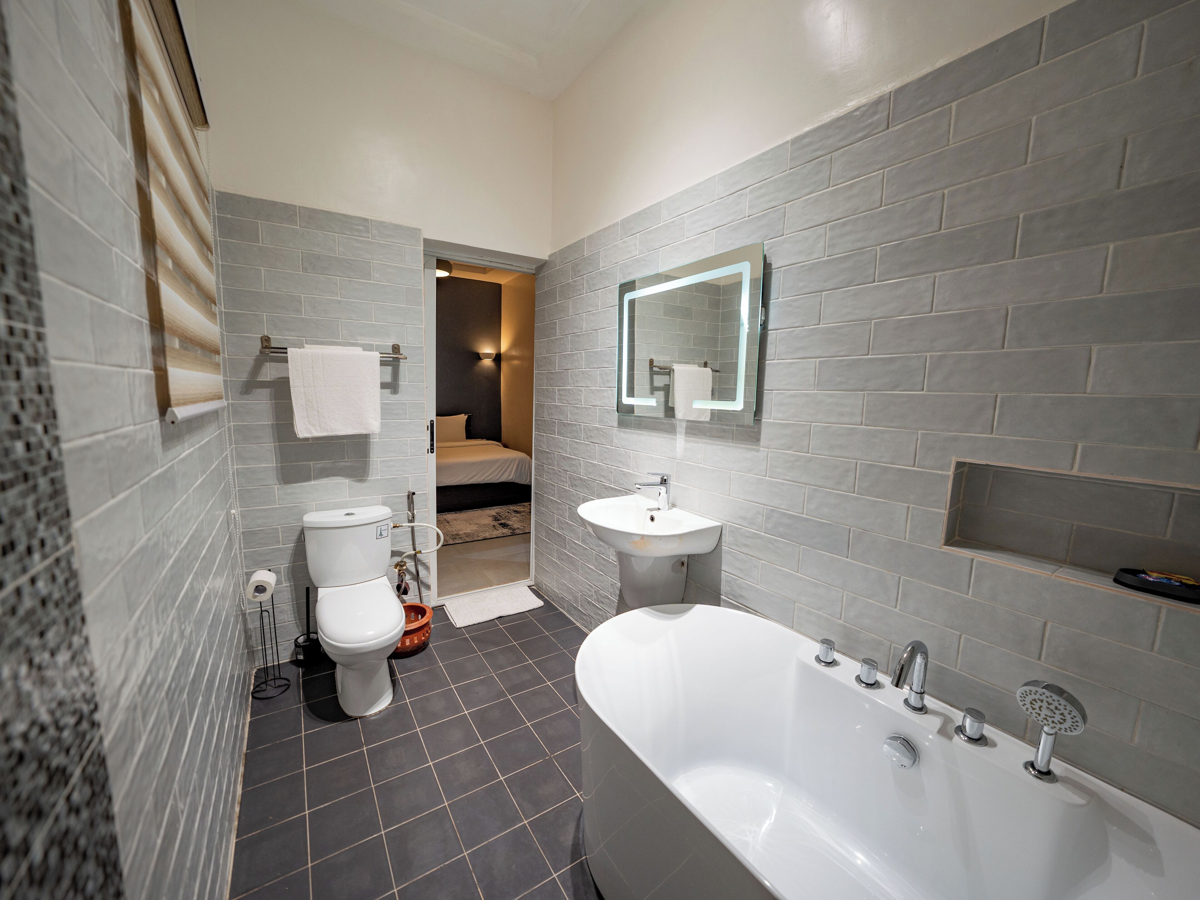 A modern bathroom with a bathtub, toilet, and sink.