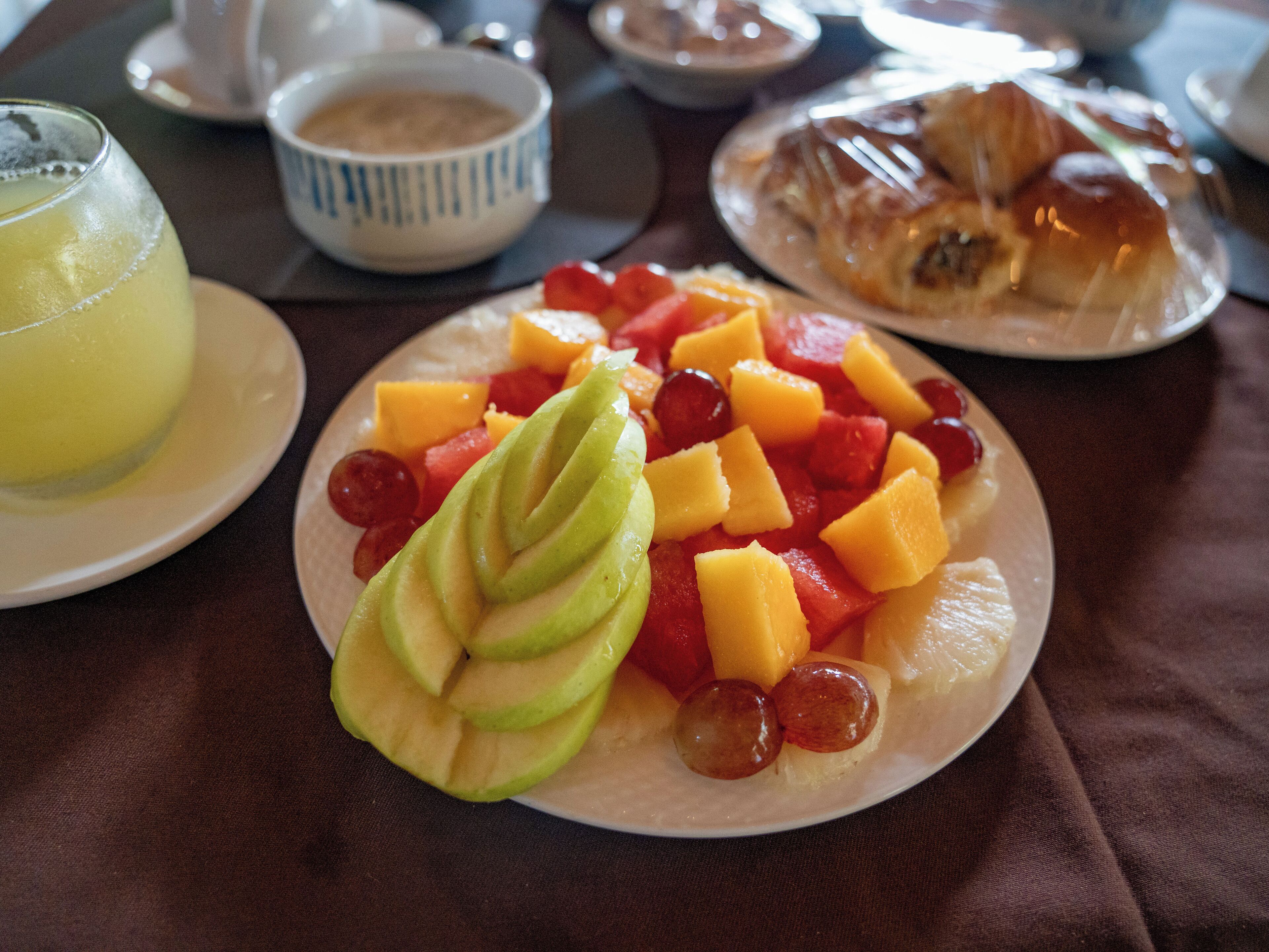 Une assiette de petit-déjeuner avec des fruits et un croissant.