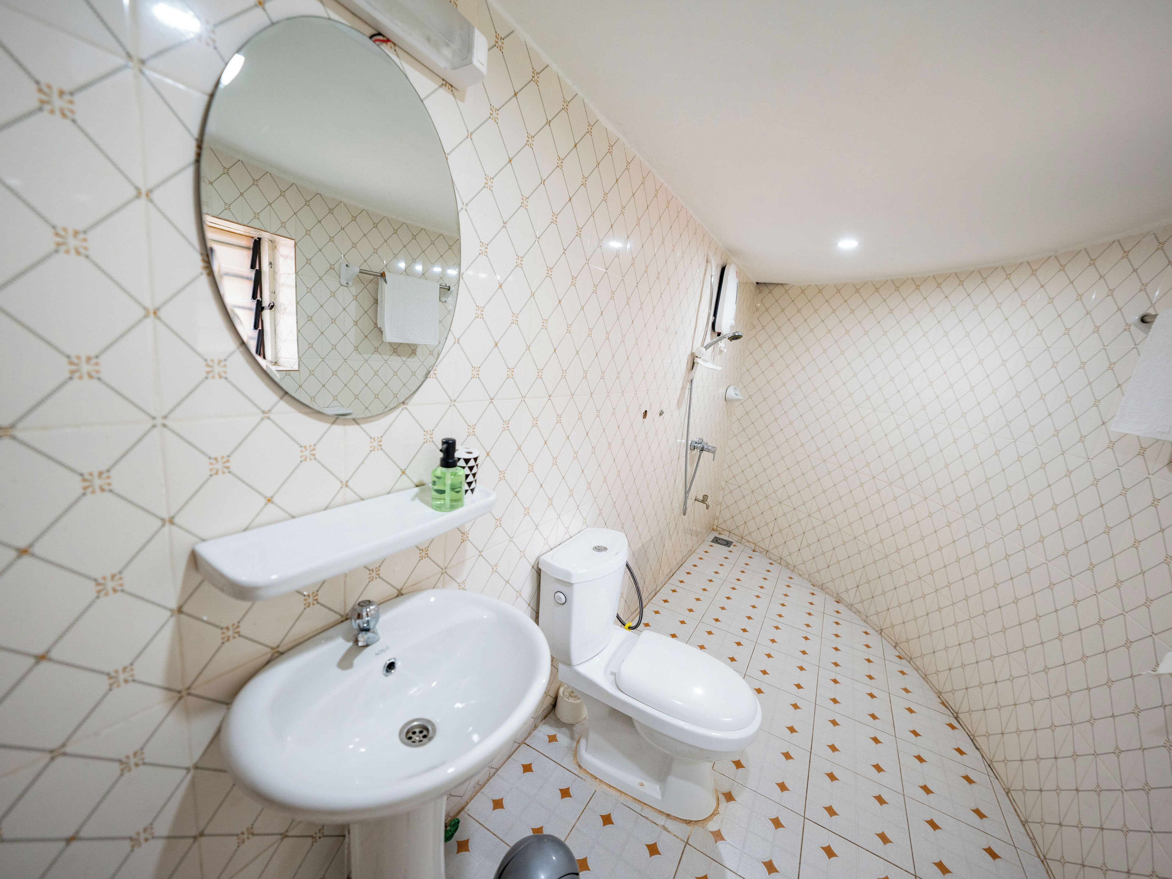 A bathroom with a sink, toilet, and a mirror.