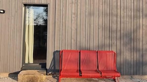 A modern building with a flat roof, a large window, and a red bench outside. - Vacation home with all the amenities (air-conditioned/sauna) (Sternenfels)