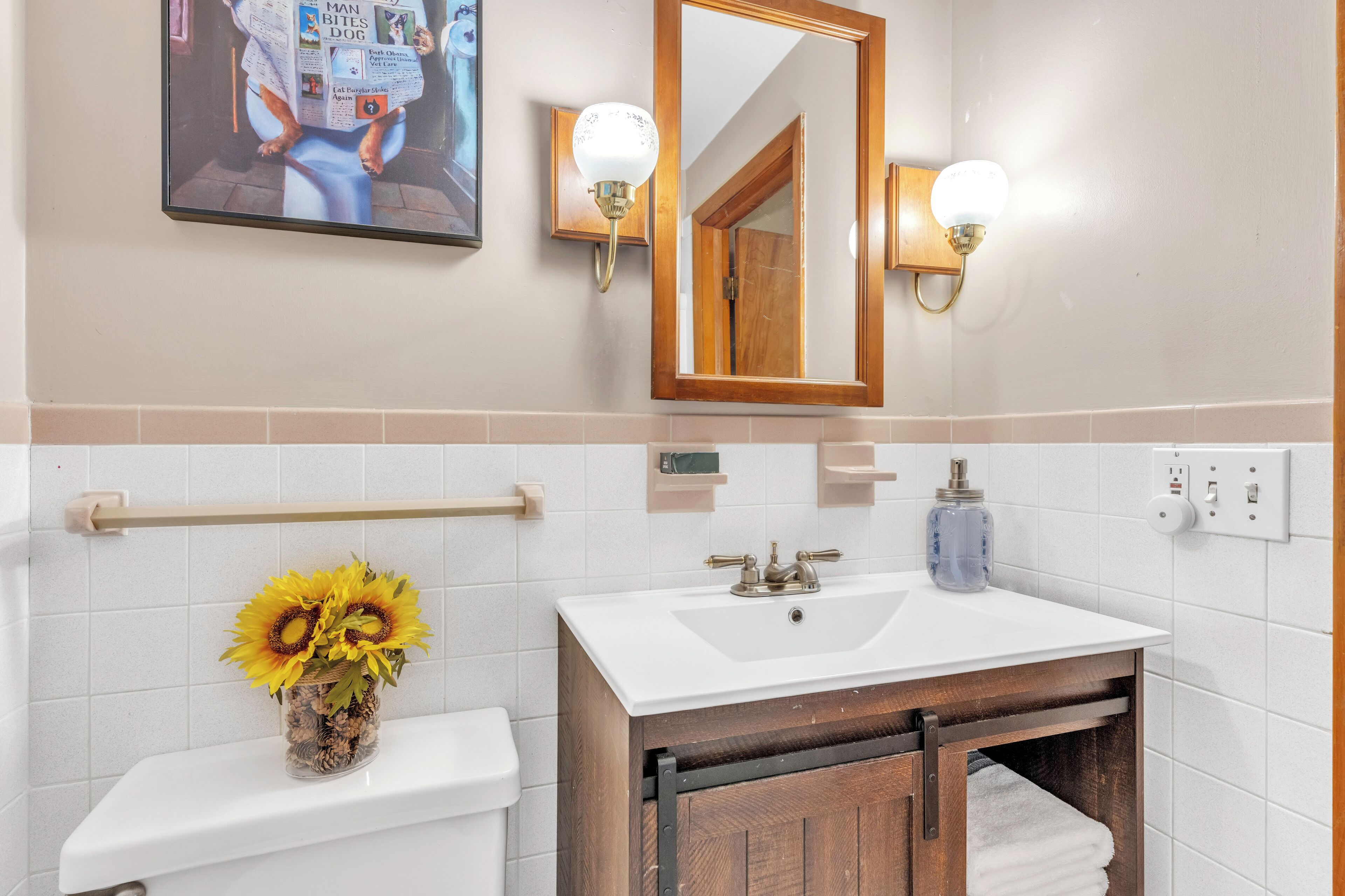 Une salle de bain avec un lavabo blanc, un miroir et un porte-serviettes.