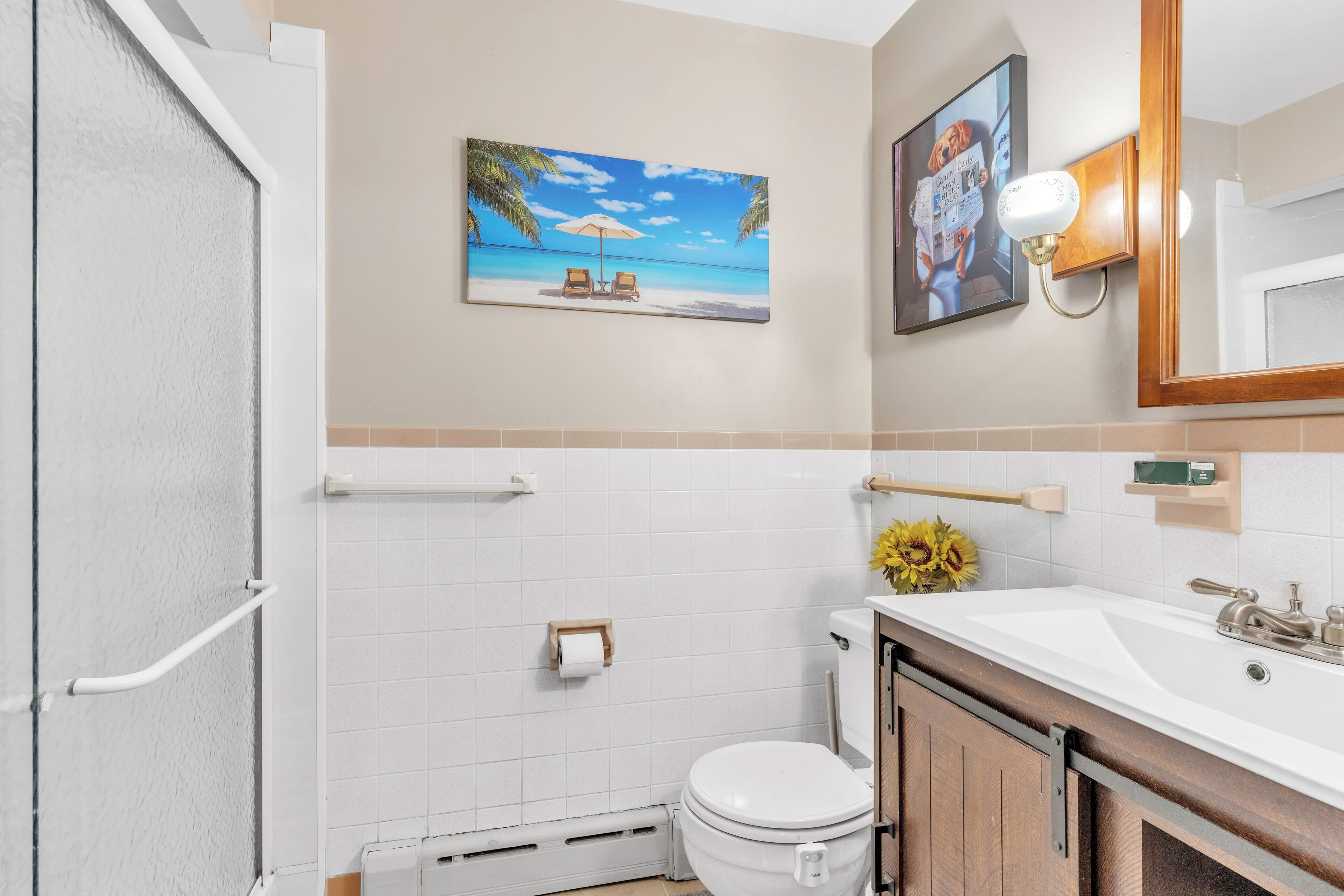 A bathroom with a toilet, sink, and a towel rack.