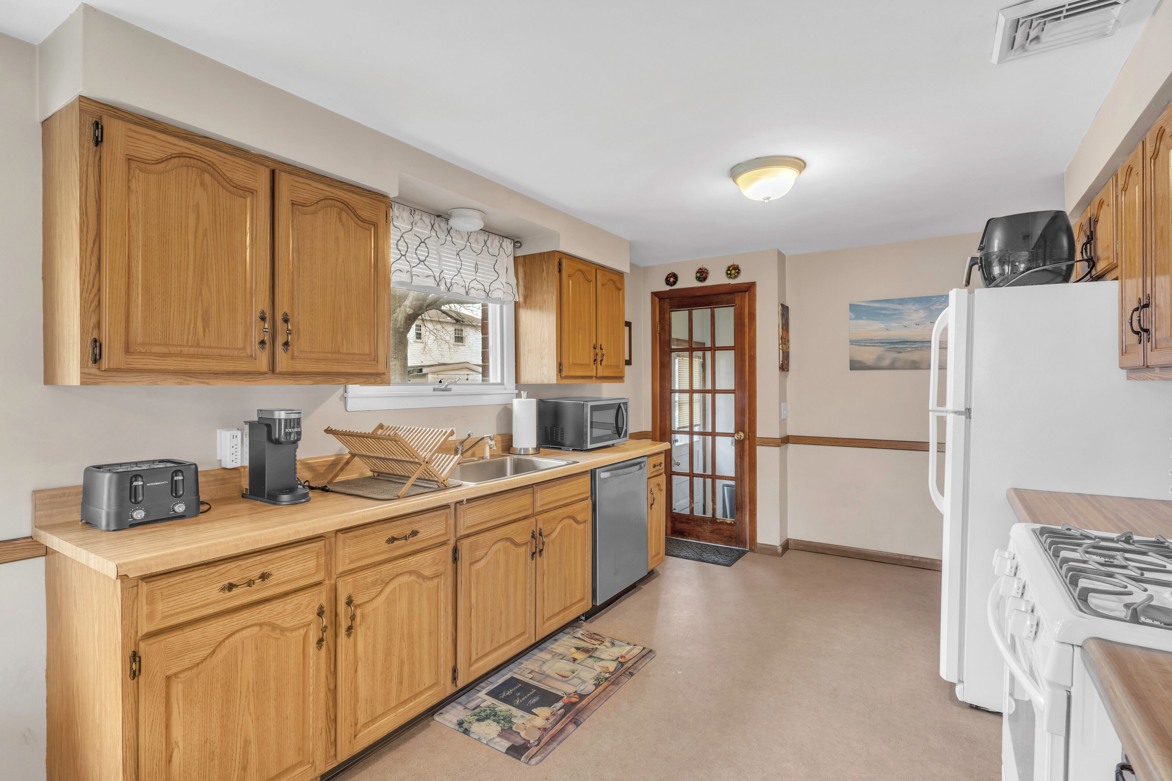 A kitchen with wooden cabinets, a stove, a microwave, and a dishwasher.