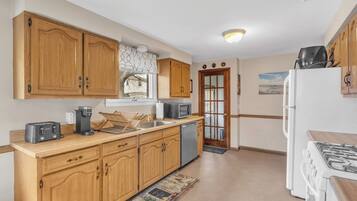A kitchen with wooden cabinets, a stove, a microwave, and a dishwasher.