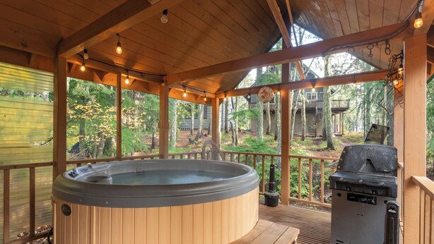 A wooden deck with a hot tub, grill, and wooden benches. - Third night free on stays before 8/30/26 (Government Camp)
