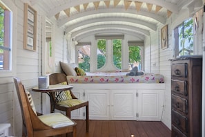 Una habitación acogedora con un banco empotrado, una mesa pequeña y una silla de madera.