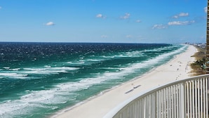 A beach with a railing, ocean waves, and a clear sky. - Emerald Isle 1301 - New listing! Front row beach chairs included! (Panama City Beach)