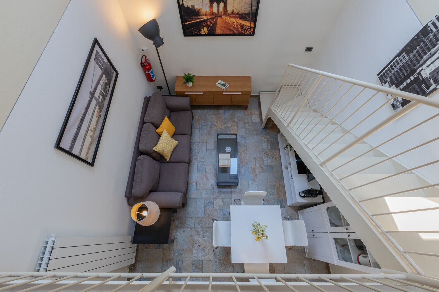 A modern apartment with a living area, a dining table, and a staircase.