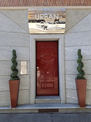 A red door with a plaque indicating "Urban Lofts" and a sign above it. - The City by Wonderful Italy (Torino)