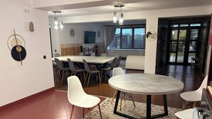 A dining area with a round table, white chairs, and a patterned rug. - Mik Chalet. Pet friendly (Săcele)