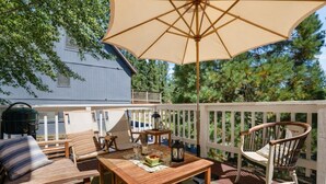 A wooden deck with a table, chairs, and an umbrella. - Walk to the lake Gorgeous lake house (Big Bear Lake)