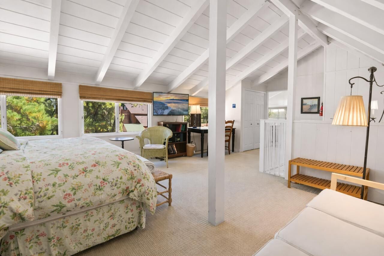 Une chambre à coucher avec un lit, une chaise, un bureau et une lampe.