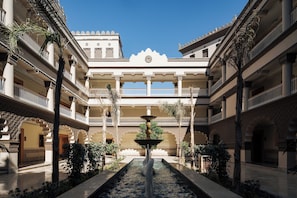 A courtyard with a central fountain, multiple balconies, and a symmetrical architectural design.