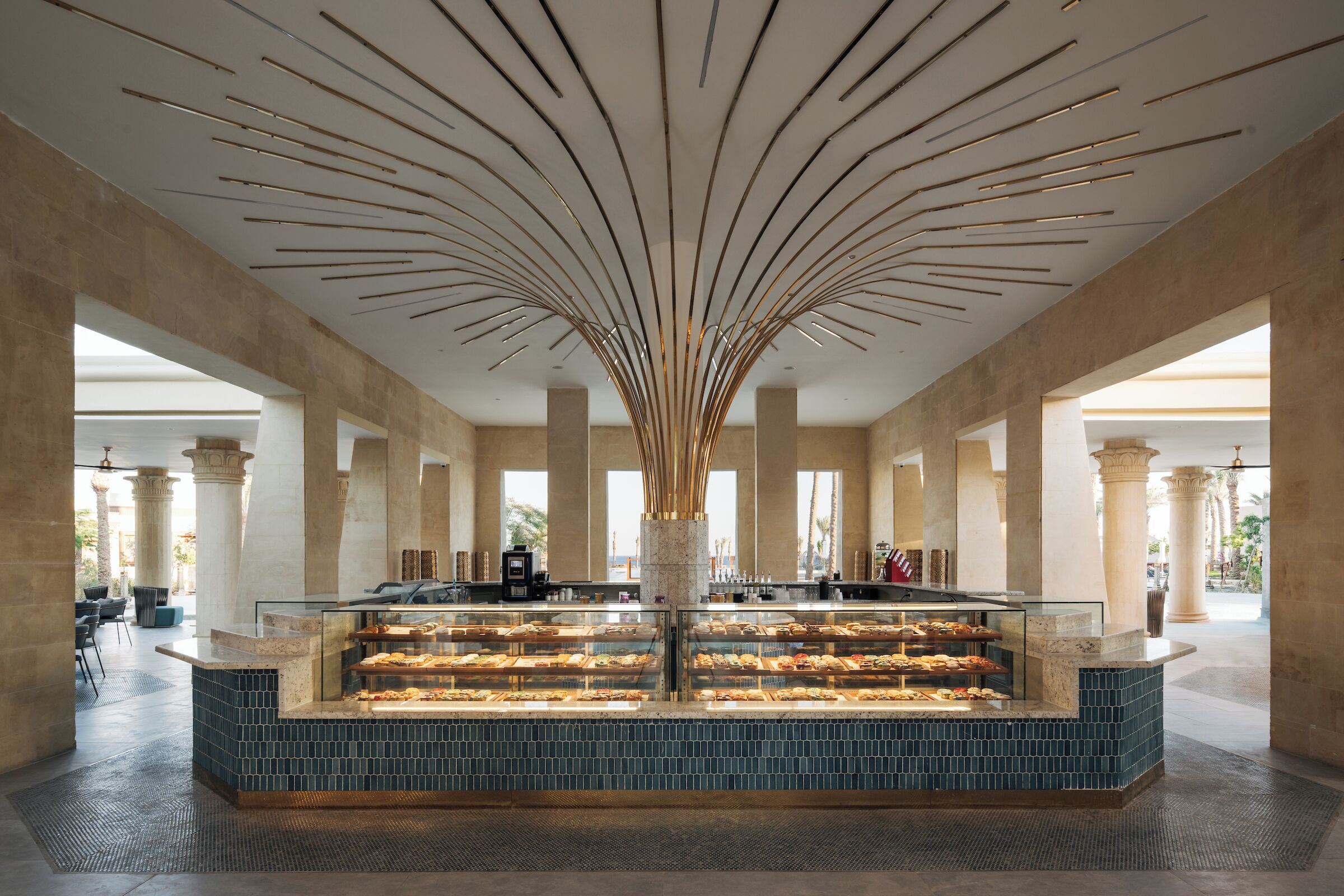 Ein modernes Interieur mit einer zentralen Vitrine, Säulen und einer Decke mit linearen Leuchten.