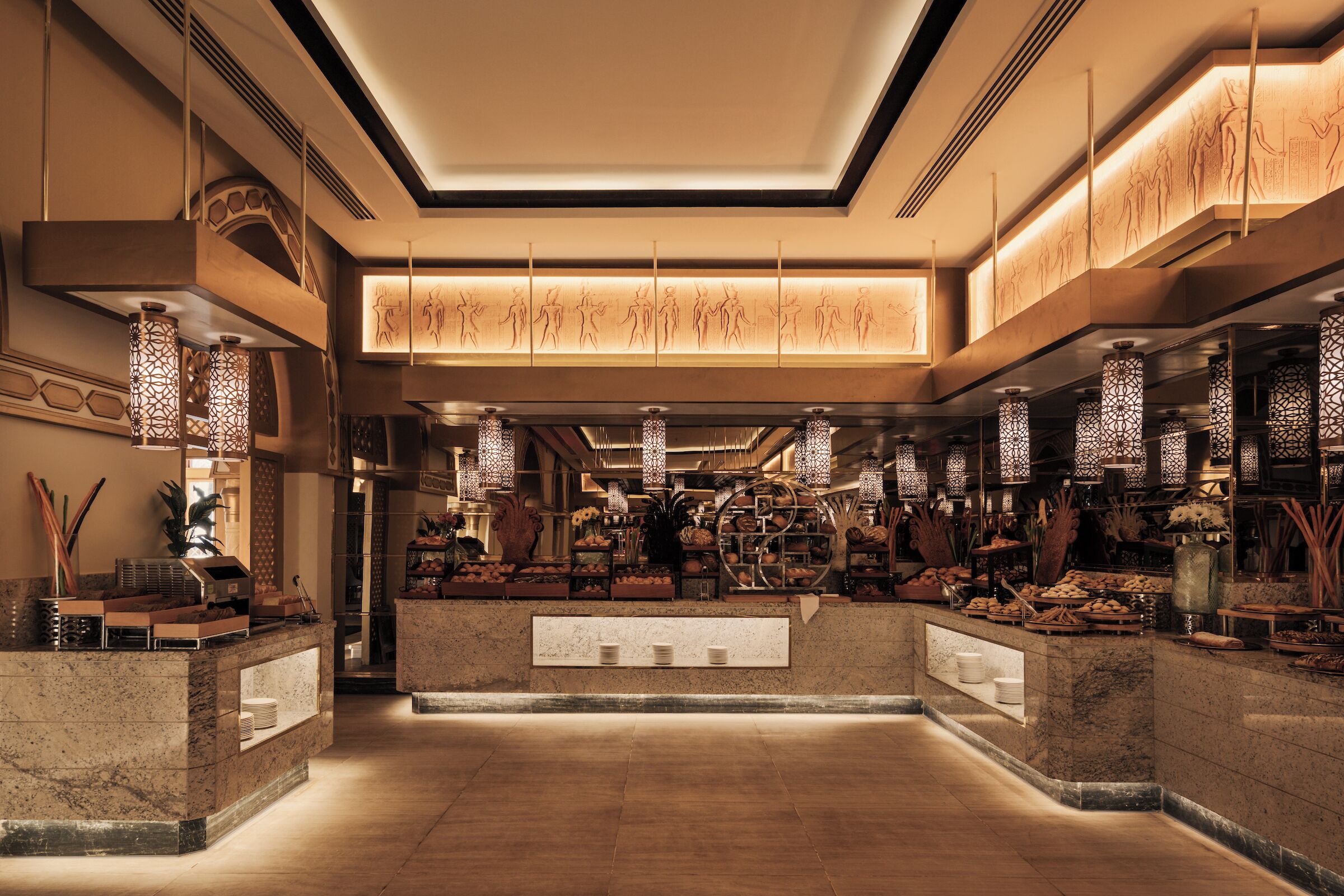 Un hall d’hôtel doté d’un comptoir d’accueil central, d’un éclairage décoratif et de nombreux équipements.