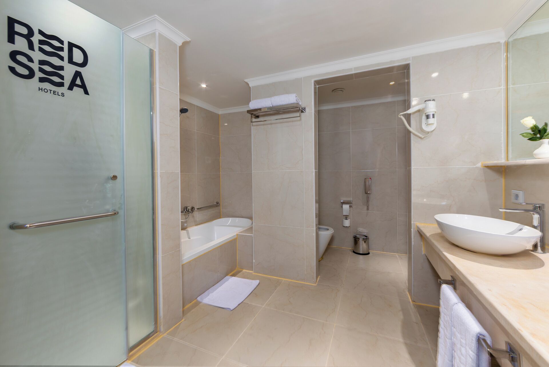 Et stilfuldt badeværelse med badekar, toilet og håndvask.