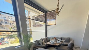 Una sala de estar moderna con un sofá, una mesa de centro de madera y una mesa de comedor preparada para cuatro.