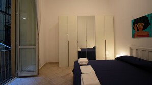 Ein Schlafzimmer mit einem Bett, einem Kleiderschrank und einem Bild an der Wand.