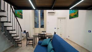 Ein modernes Interieur mit einer Treppe, einem Essbereich und einem blauen Sofa.