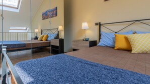 Quarto com cama, mesas de cabeceira, luminárias e uma pintura de paisagem urbana na parede.