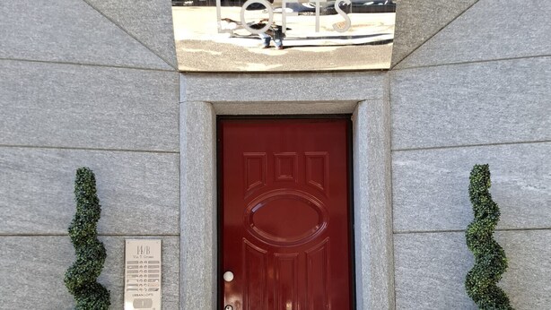 Uma porta vermelha com uma placa indicando "Urban Lofts" e um letreiro acima.