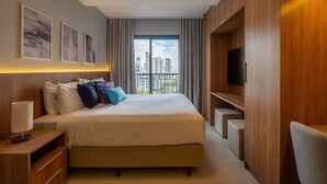 A hotel room with a large bed, a TV, and a city view. - Upper West Perdizes by Xtay (São Paulo)