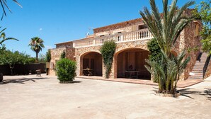 Un pati amb un edifici de pedra que presenta portals d'arc i un balcó.