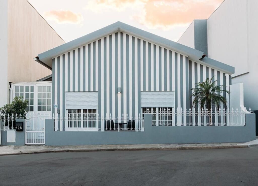 Un bâtiment moderne doté d’un toit plat, d’un revêtement vertical et d’une entrée sécurisée par un portail.