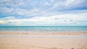 Une plage avec un ciel dégagé et une mer calme.