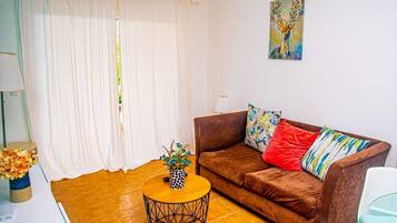 Apartamento família, piscina particular, vista para o jardim | Área de estar