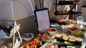 Ein reichhaltiges Buffet mit verschiedenen Speisen, darunter Fleisch, Käse, Gebäck und Obst.