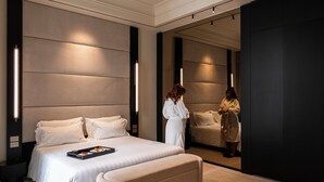 Ein modernes Hotelzimmer mit einem großen Bett, Nachttischen und einem Spiegel.