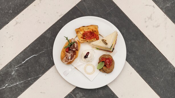 A plate with various food items on a tiled floor. - Sparano Palace (Bari)