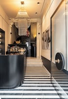 Un interno moderno con un'area bar, una scala e una porta con maniglia tonda.