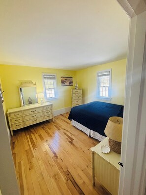 Ein Schlafzimmer mit Bett, Schminktisch und einer Kommode.