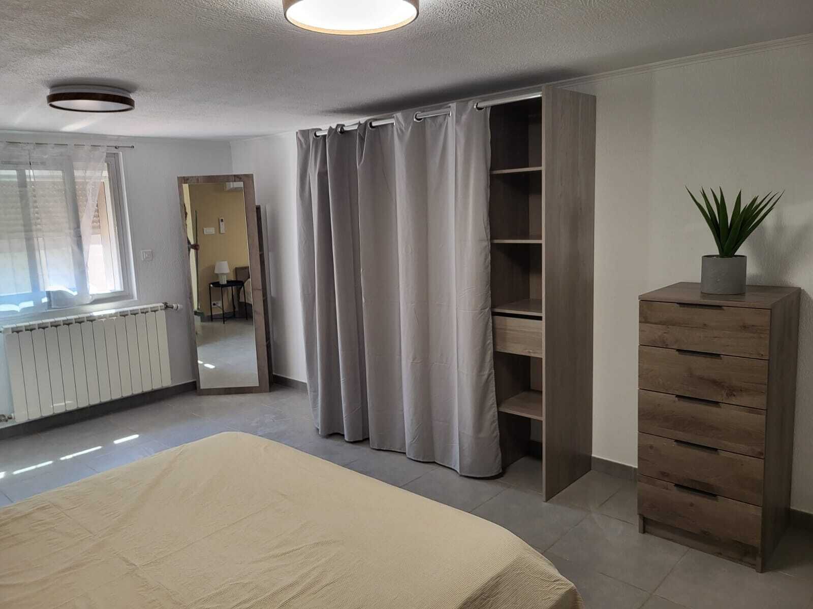 Une chambre à coucher avec un lit, une armoire, un radiateur et un miroir.