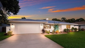 A single-story house with a garage, a well-maintained lawn, and solar panels on the roof. - New listing discount! 5BR luxe oasis: Pickleball+bowling+golf+game room & more! (Bradenton)