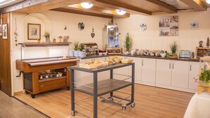 Un café acogedor con vigas de madera, una máquina de café y una variedad de pasteles a la vista.