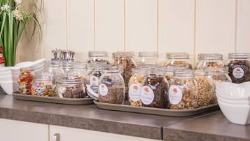 Una encimera de cocina con varios frascos de vidrio que contienen distintos alimentos, cada uno con una etiqueta diferente.