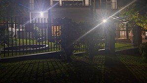 A modern two-story house with a well-lit entrance and a gated driveway. - Marion guest house (Ballito)