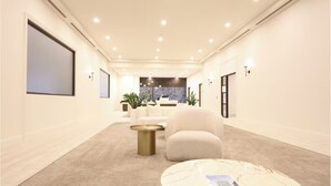 A modern hotel lobby with a carpeted floor, a reception desk, a white sofa, and a marble coffee table. - Home in the Sky 2BR,2BA with City Views,Pool & Gym (Melbourne)