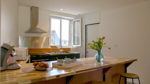 Une cuisine moderne dotée d’un plan de travail en bois, d’un évier et d’une fenêtre donnant sur l’extérieur.