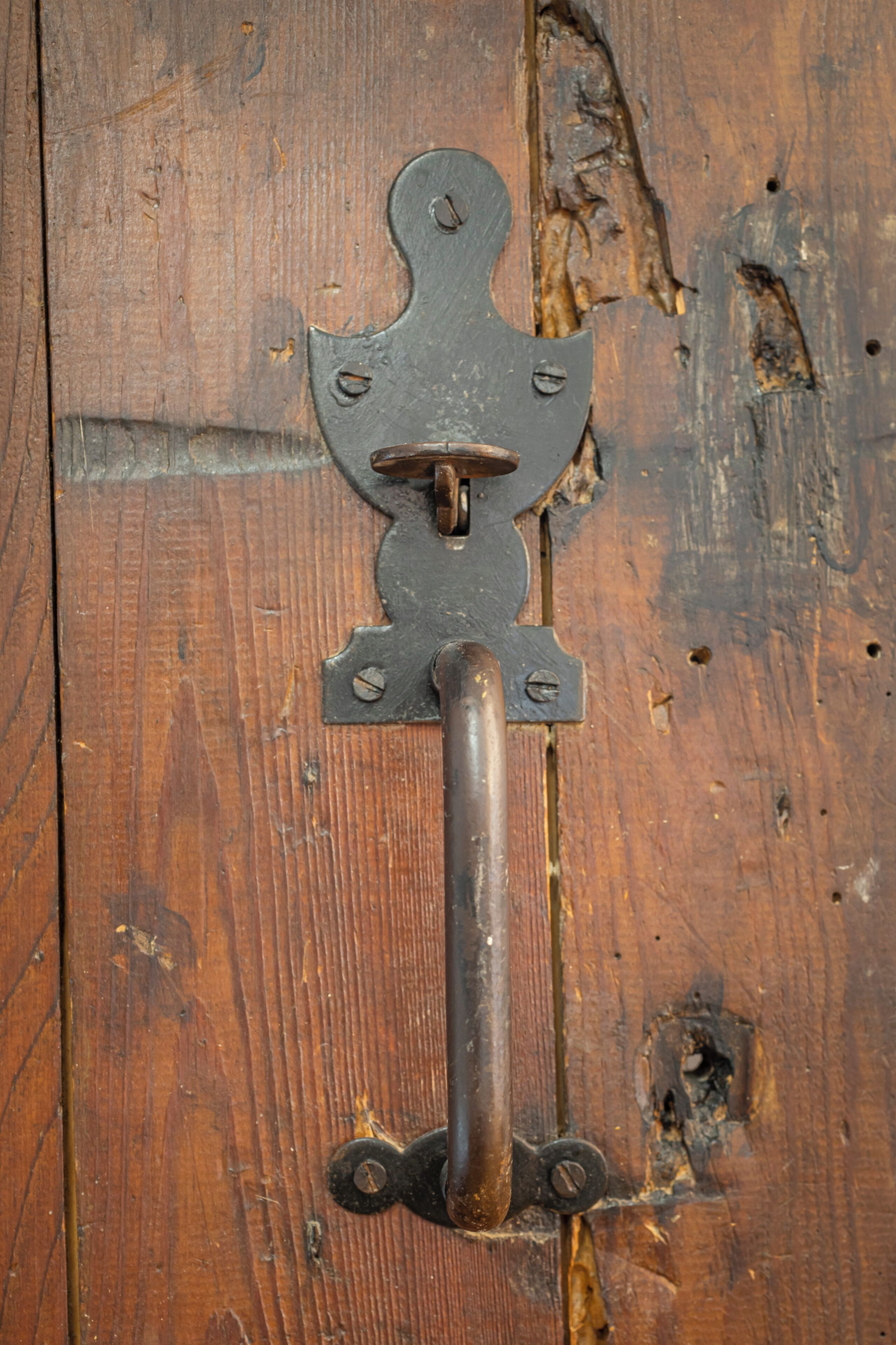 A metal latch on a wooden door.